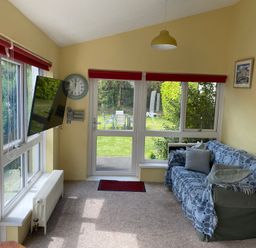 A snug with a television and clock at Kenvor in Newport, Pembrokeshire