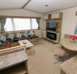 A living room with a sofa and television at 82 Manorbier Park in Manorbier