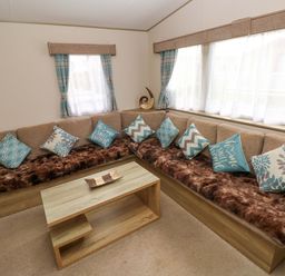 A living room with a sofa and coffee table at 82 Manorbier Park in Manorbier