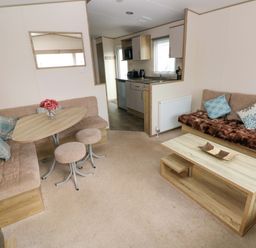 A living room with a dining table and sofa at 82 Manorbier Park in Manorbier
