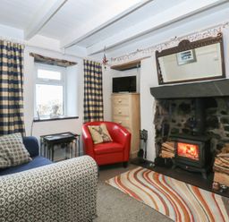 A living room with a fireplace and sofa at Parc y Brenin Holidays, Abersoch