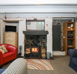 A living room featuring a fireplace and two seating areas at Parc y Brenin Holidays, Abersoch