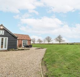A house with a gravel pathway and outdoor furniture at Ivy Barn Norwich