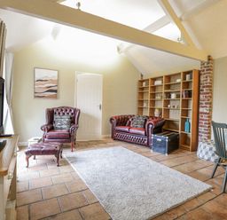 A living room with a television and sofas at Ivy Barn in Norwich