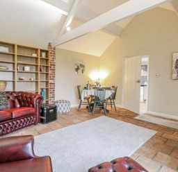 A living room with a sofa and dining table at Ivy Barn in Norwich
