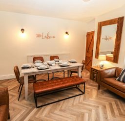 A dining room with a table set for meals at Waterhead Cottage in Ambleside