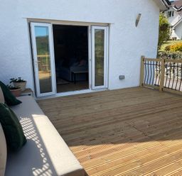 An outdoor area with a sofa and potted plant at Inglewood Bach in Conwy