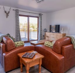 A living room with a sofa and coffee table at Star Carr Lakes