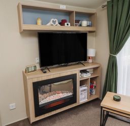 A living room with a television and a fireplace at Homeslea 33 Millennium Gardens Morpeth