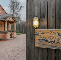An outdoor area with a sign and lamp at Otter's Rest in Droitwich