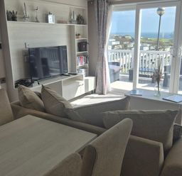 A living room with a television and sofa at 21 Gorse Hill in Exmouth
