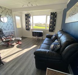 A living room with a chair and table at Chalet 333 in California, Norfolk
