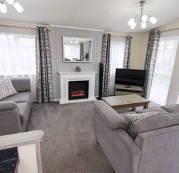 A living room with a sofa and television at Lily's Lodge in Morecambe
