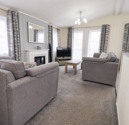 A living room with sofas and a television at Lily's Lodge in Morecambe
