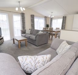 A living room with a sofa and dining area at Lily's Lodge in Morecambe