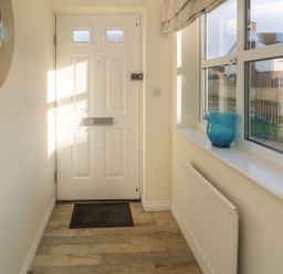 A hallway with a door and windows at Sandy Cove, Chathill