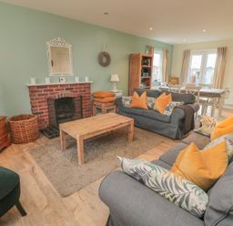 A living room with a sofa and coffee table at Sandy Cove in Chathill