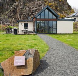 An exterior view of Summerset Lodge with a pathway and seating area