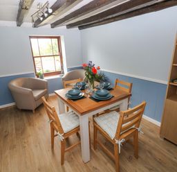 A dining room with a table set for four at Beacon House in Marloes near Little Haven