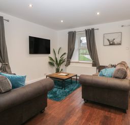 A living room with a television and seating arrangements at 6 Hallin Fell in Penrith
