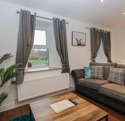 A living room with a sofa and window at 6 Hallin Fell in Penrith