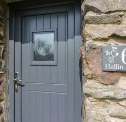 A front door of a property with stone wall at 6 Hallin Fell Penrith