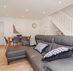 A living room with a sofa and dining area at Creek Lodge in Chacewater