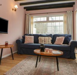 A living room with a sofa and coffee table at 1 Alpha Cottages in Tenby
