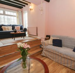 A living room with two sofas and a flower vase at 1 Alpha Cottages in Tenby