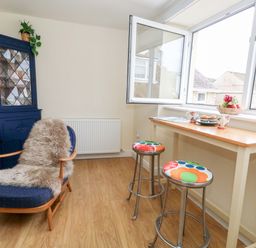 A kitchen with an armchair and a table at Flat 3