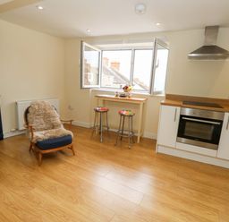 A kitchen with stools and an oven at Flat 3