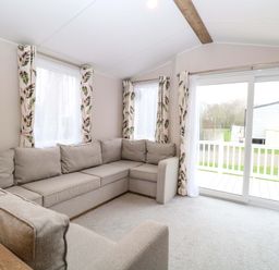 A living room with a sofa and windows at Caravan in Great Yarmouth