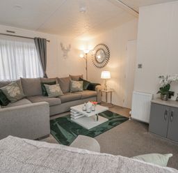 A living room with a grey sofa and a coffee table at The Ridgeway in New Quay