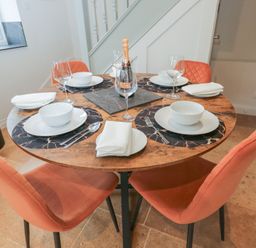 A dining table set with plates and wine glasses at Paddock View Stow-On-The-Wold