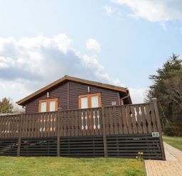 A lodge with a balcony and pathway at Nevaeh Lodge Longframlington