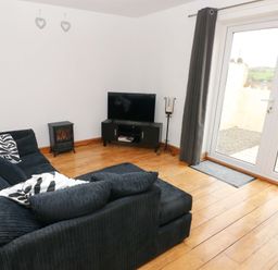 A living room with a sofa and television at Red Kite Cottage in Haverfordwest