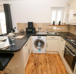 A kitchen with a washing machine and countertop space at Red Kite Cottage Haverfordwest