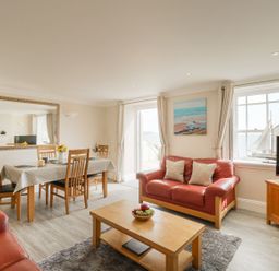 A living room with a dining area and sofa at Ocean Wave in Greenhill