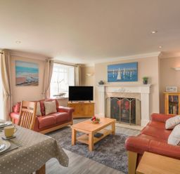A living room with a sofa, coffee table, and fireplace at Ocean Wave in Greenhill