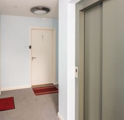 A hallway with an elevator and door at Mill Wharf in Berwick-upon-Tweed