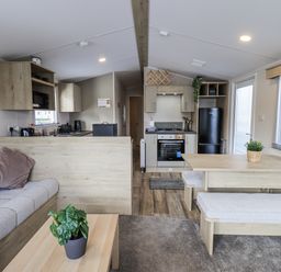 A living room with a sofa and dining area at Hadrian's Rest in Wigton