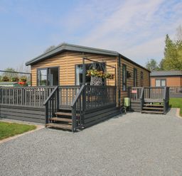 A modular home with a deck and garden in Poppy Eardisland
