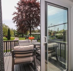 A deck with outdoor furniture overlooking a garden at Poppy in Eardisland