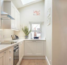 A kitchen with cabinets and appliances at Juniper Cottage