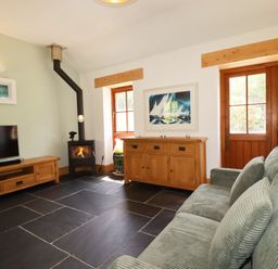 A living room with a sofa and television at Little Trethellan in Trethellan near Lanner