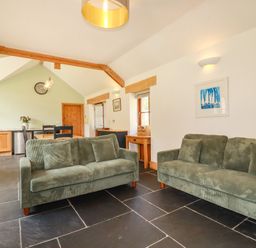 A living room with two sofas and a table at Little Trethellan in Trethellan near Lanner
