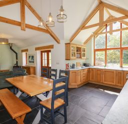 A kitchen with dining area and large windows at Little Trethellan in Trethellan near Lanner