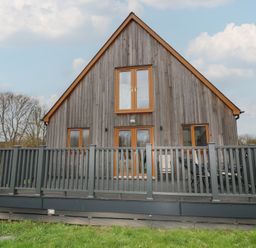 A house with a deck and windows at Pumpkin Lodge in Brigg