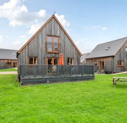 A view of several houses with a deck and grass area at Lodge 25 - Pumpkin Near Brigg