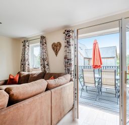 A living room with a sofa and balcony access at Lodge 25 - Pumpkin near Brigg